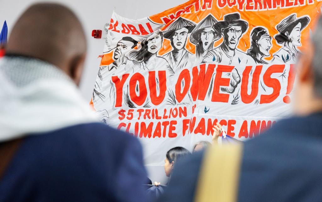 Poster reading 'You owe us' at COP29.