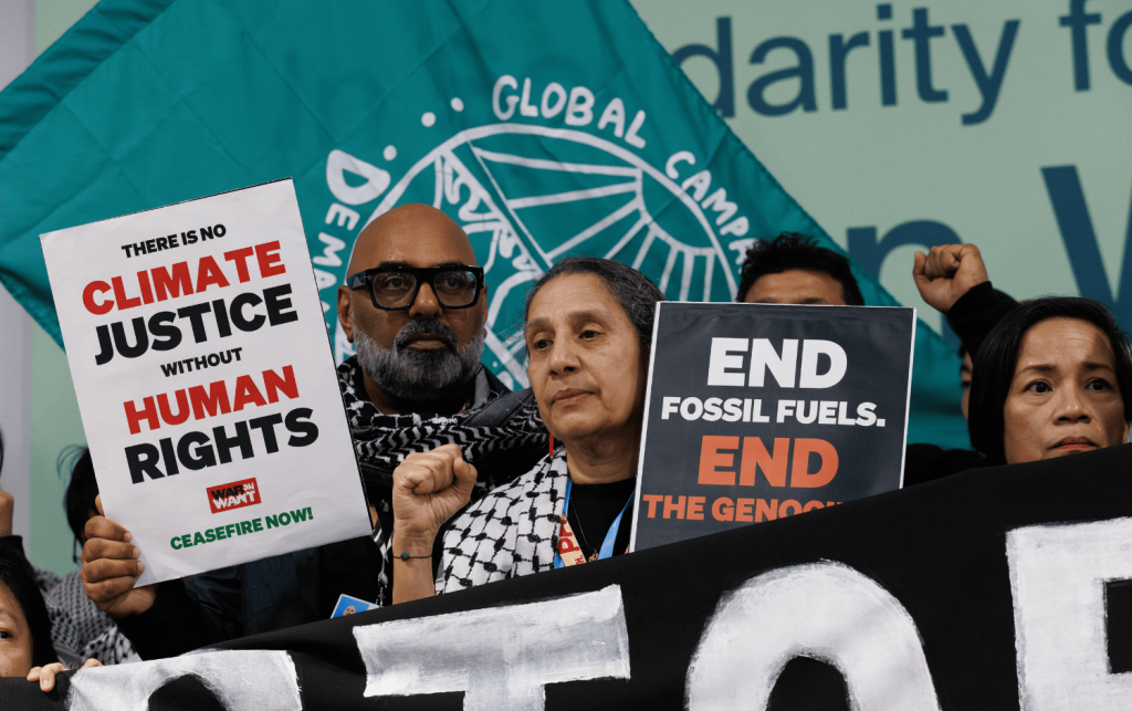 Activists hold posters saying 'No climate justice without human rights'